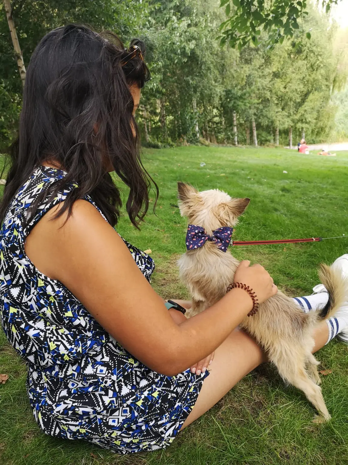 Sophia in the park petting a dog stood on their lap